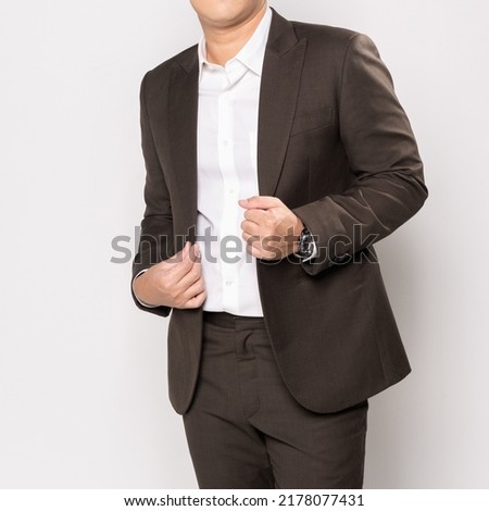 A man model posing wearing a brown suit standing on white background