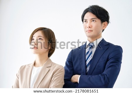 Portrait of Asian businesswoman and a businessman with crossed arms in white background