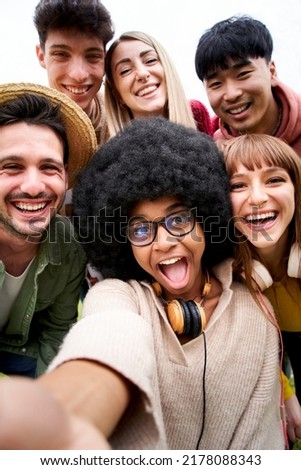 Vertical photo of Cheerful group of friends taking smiling selfie. Group of young people having fun together outdoors at park in the city enjoying travel in vacation holidays.