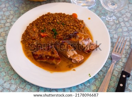 Delicious pork tenderloin with mousserons sauce and lentils on plate