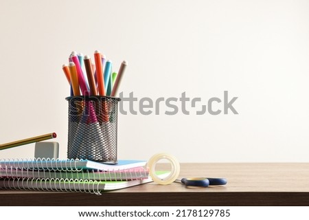School supplies with pen with markers on notebooks with tools on wooden desk. Front view. Horizontal composition. Royalty-Free Stock Photo #2178129785