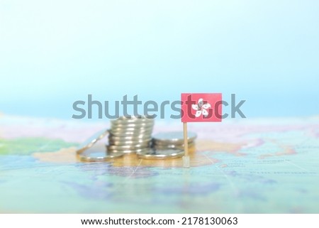 Selective focus of Hong Kong flag in blurry world map with coins. Hong Kong economy and wealth concept.
