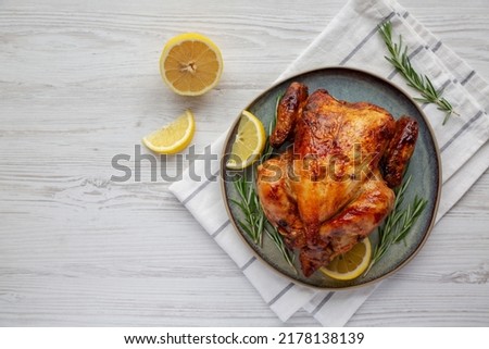 Homemade Lemon and Herb Rotisserie Chicken on a Plate, top view. Flat lay, overhead, from above. Space for text. Royalty-Free Stock Photo #2178138139