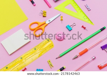Supplies creative tools for school creative work on pink background with pattern stationery, colored paints brushes pencils, pens notepad on a spiral copy space, flat set, mock up