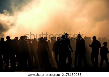 People silhouette with heavy smoke from burnt tyres on drift contest, concept of people on drift car event Royalty-Free Stock Photo #2178150085