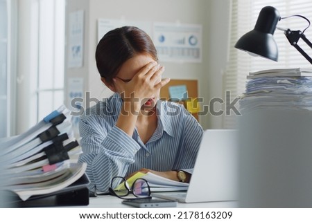 Tried young Asian office employee feeling sick and have a headache from a long working day at office Royalty-Free Stock Photo #2178163209