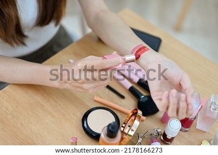 Top and closeup shot, Female testing or swatching lipstick on her arm. Female beauty blogger or makeup artist concept