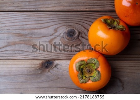 Photo of persimmons on a wooden board.