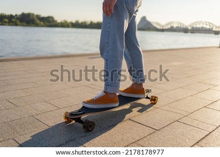 Closeup man feet riding in sporty shoes on boardwalk. Active skater legs practicing skateboarding on city street.