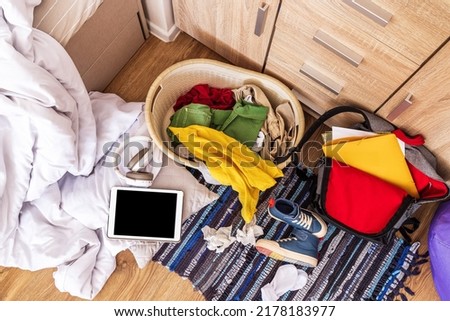 colored things are scattered on the floor in a big mess, top view. Teenage room Royalty-Free Stock Photo #2178183977