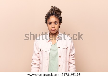 young afro woman feeling sad and whiney with an unhappy look, crying with a negative and frustrated attitude