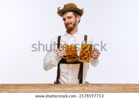 Young expressive man in hat, wearing fest traditional Bavarian or German costume with big beer glass isolated on white background. Alcohol, traditions, holidays, Oktoberfest concept. Copy space for ad Royalty-Free Stock Photo #2178197713