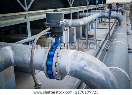 Open or close valve of cooling tower,butterfly valve beside of cooling Tower,screwing valve building cooling system,maintenance in working condition,anti-rust,rust is big problem of piping system. Royalty-Free Stock Photo #2178199923