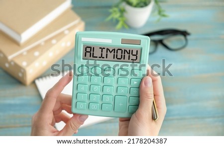 Word ALIMONY written on calculator on office table. Royalty-Free Stock Photo #2178204387