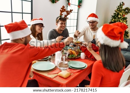 Group of young people smiling happy having christmas dinner at home.