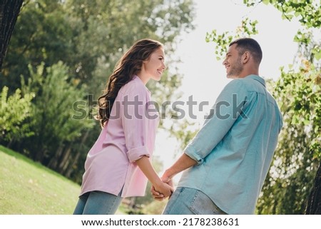 Photo of two peaceful idyllic people hold arms look each other enjoy warn nice weather outdoors