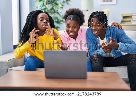 African american friends having video call sitting on sofa at home