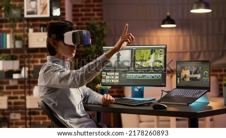 Videographer using editing software and vr glasses to design montage for movie production. Edit film footage with visual effects on computer, working with virtual reality goggles.