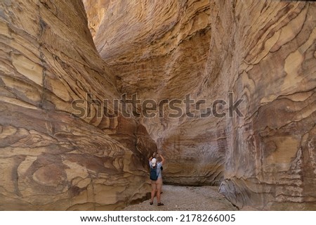 Stunning Dana Biosphere Reserve in Jordan. Colorful rocks in Wadi Ghuweir Canyon. Silhouette of man taking photo.