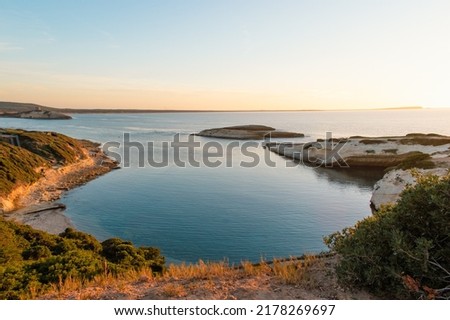 Turquoise calm water with wave with sand beach background smooth and rough rocks and corals landscape cloudy view in sunset. Concept summer