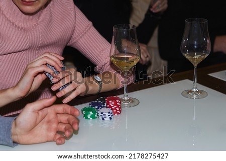 Woman holding cards in poker game. Cards, dices and glasess of champagne. Candid moment. Poker background lifestyle photography. Enjoying the moment, digital detox with friends