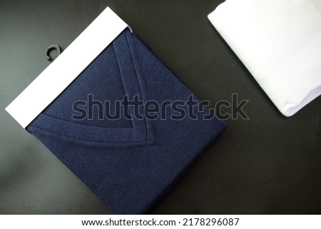 Dark blue v-neck shirt in packaging. Shopping, fashion, clothes style concept