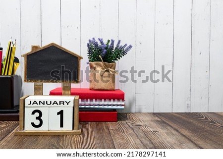 January 31 calendar date text on white wooden block with stationeries on wooden desk. Calendar date concept.