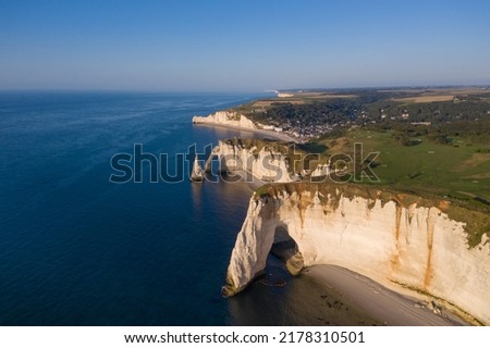 Aerial view of the coastal cliffs of Etretat in Normandy, France, at sunset. Alabaster coast from a drone and erosion of the famous chalk cliffs Royalty-Free Stock Photo #2178310501