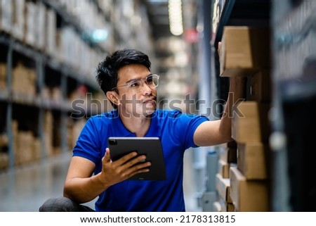 Warehouse Worker in safety suite using digital tablets to check the stock inventory in large warehouses, a Smart warehouse management system, supply chain and logistic network technology concept. Royalty-Free Stock Photo #2178313815