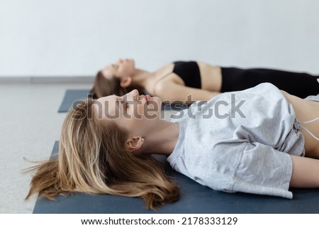 Fitness group doing practicing in a yoga class. Shavasana or corps pose, yoga practice Royalty-Free Stock Photo #2178333129