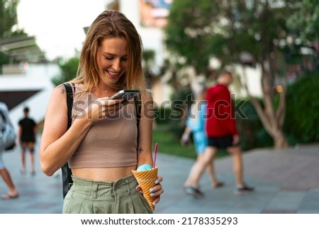 Young woman takes pictures of ice cream on her smartphone