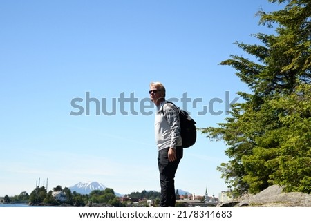 An mature adult male looking out over the vast alaskan wilderness.