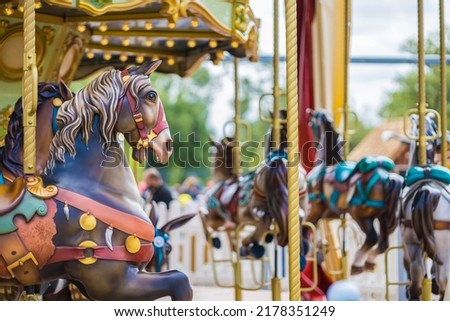 Children's carousel with retro-style horses. A fragment of a multi-colored vintage carousel in the park.