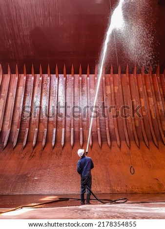 ship crews are performing cargo hold cleaning on a bulk carrier. preparing for loading cargo. Royalty-Free Stock Photo #2178354855
