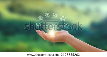 Hand holding hologram with icons, energy sources for renewable, sustainable development. Ecology concept.
