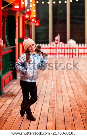 The girl walks around the New Year's town. She is happy and cheerful. Christmas, New Year, holidays. New Year's location