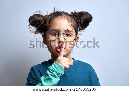 Shh little brunette girl asks to keep silence and secret isolated on white background