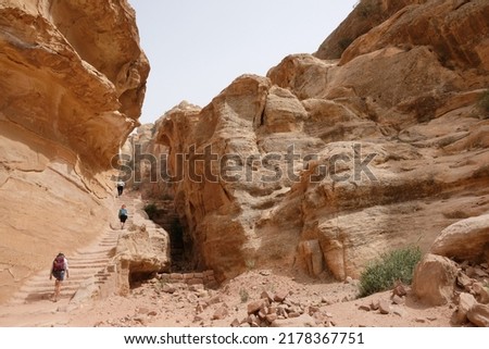 Amazing views on tourist trail to High Place of Sacrifice in ancient Nabataean city of Petra, Jordan. Petra is considered one of seven new wonders of world. Silhouettes of people on trail. Royalty-Free Stock Photo #2178367751