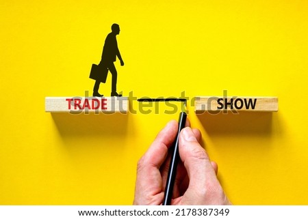 Trade show symbol. Wooden blocks with concept words Trade show on beautiful yellow background. Businessman icon. Businessman hand. Business economic financial trade show concept. Copy space.