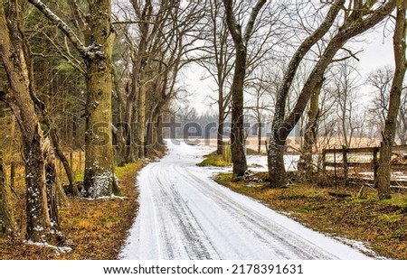 A rural road covered with snow. Winter snow road in countryside. Rural winter snow road. Snow road in winter countryside Royalty-Free Stock Photo #2178391631