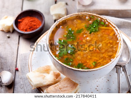 Lentil soup with smoked paprika and bread in a ceramic bowl on a wooden background Royalty-Free Stock Photo #217840411