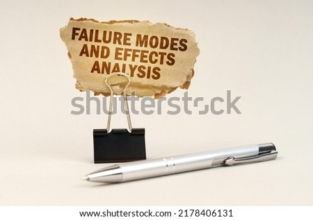 Industry and business concept. Next to the handle is an office clip with a sign. On the plate is the inscription - Failure Modes and Effects Analysis Royalty-Free Stock Photo #2178406131