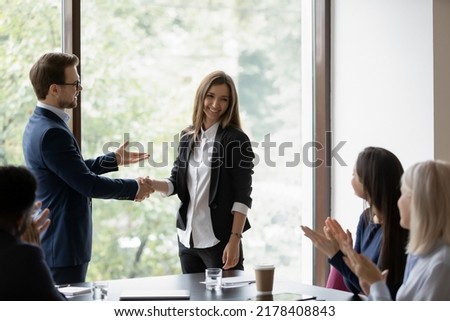 Male businessman ceo executive shaking hand of smiling happy millennial woman manager hiring her on meeting, company workers clapping hands welcoming new female teammate presented by boss employer Royalty-Free Stock Photo #2178408843