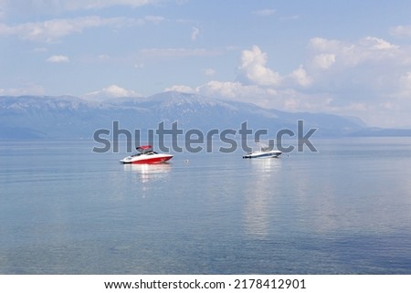 Two boats on blue water surface with horizon panoramic view of lake Ohrid  