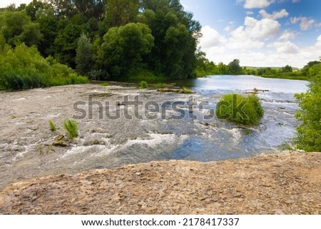 Winding river in a summer forest in cloudy weather with rain clouds. Landscape in the river forest