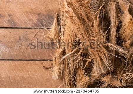 coconut husk fiber or coir on wooden table top, commercially important natural fiber extracted from outer husk of coconut fruit, taken from above with space for text Royalty-Free Stock Photo #2178464785