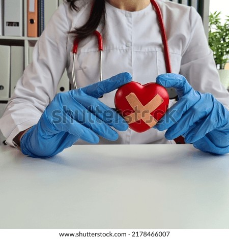 Doctor cardiologist holds sick heart in cardiology. Heart disease and treatment concept