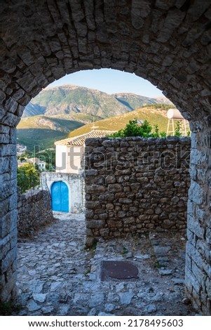 View over a classic traditional Mediterranean village through the house arch and a rock pavement Mediterranean style. Picture taken in Albanian city of Himara the old part. Albania