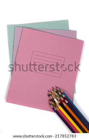 Set of colored pencils in a stack is assembled on top of school notebooks isolated on white background