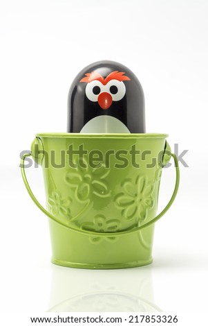 Penguin toy figure in the a bucket
